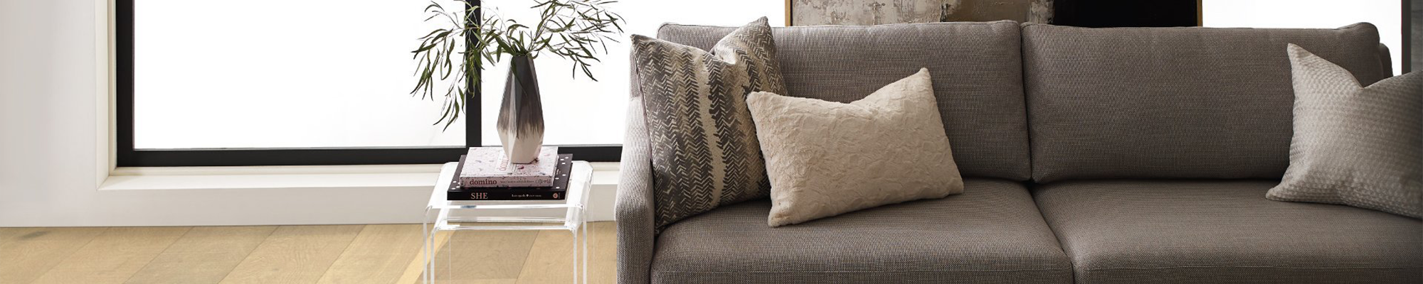 brown couch with side table in front of large window